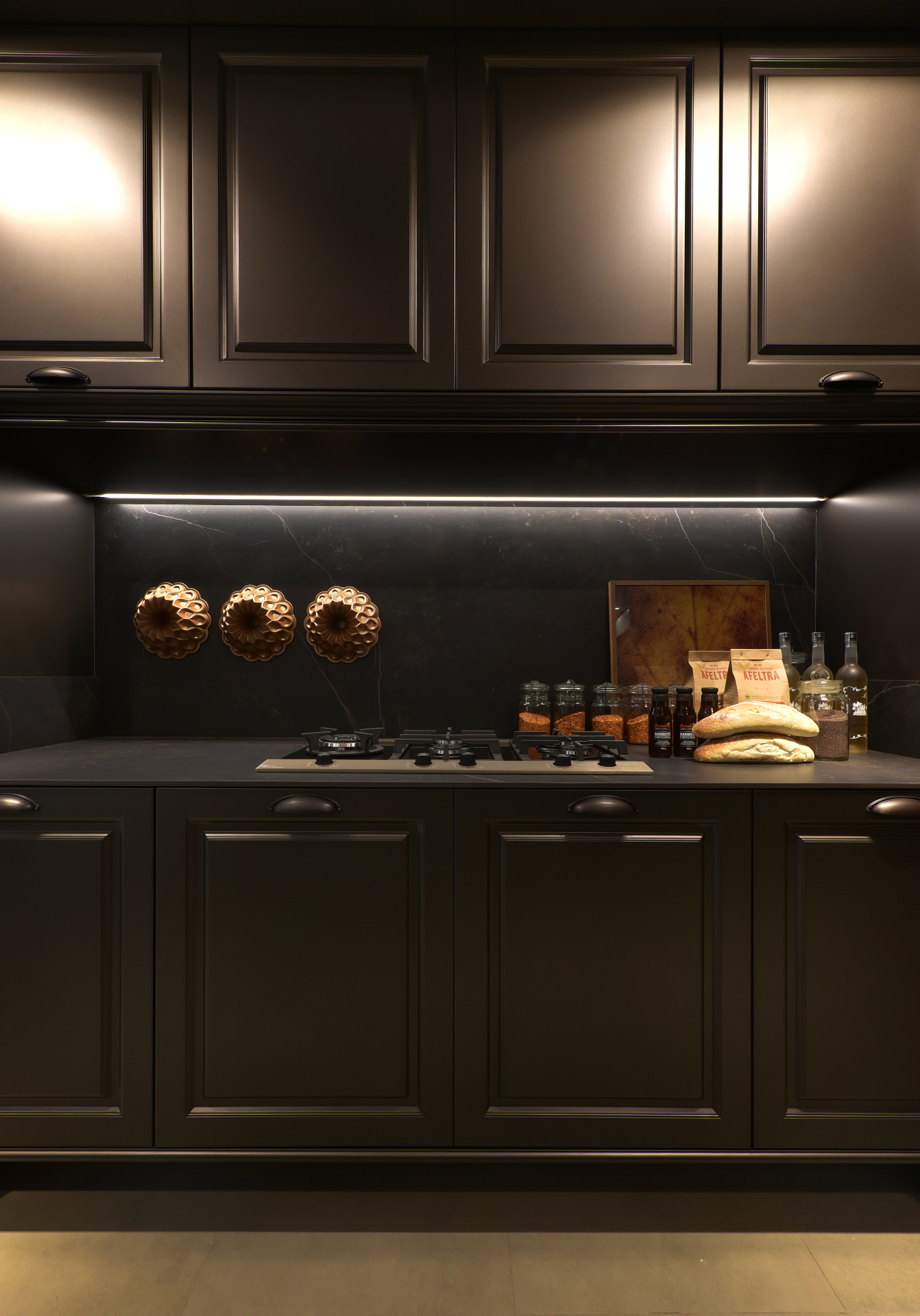 Dark bespoke kitchen with backlit stone backsplash